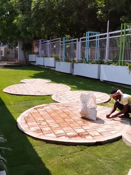 My team laying circular brick patios at the Acharya Institute. This project involved integrating hardscaping elements into a large lawn area to create functional and decorative seating zones.