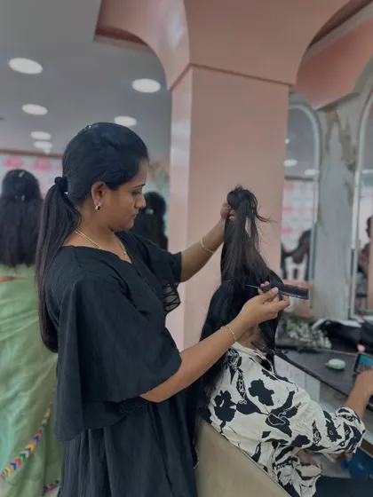 A student working on a modern bridal hairstyle during a practice session.