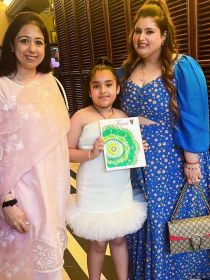The birthday girl with her family, holding the beautiful mandala art she created. It's a wonderful keepsake from her special 10th birthday celebration.