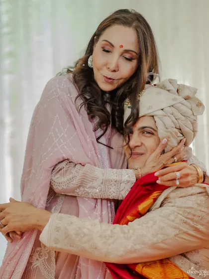 A mother's tender embrace for her son, the groom, on his wedding day. A quiet, powerful moment.