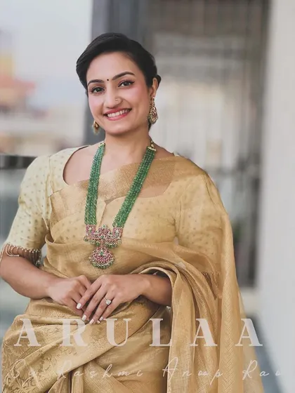 A full look at the tussar silk saree and custom blouse. The simplicity of the outfit allows the luxurious fabric and statement jewelry to stand out.