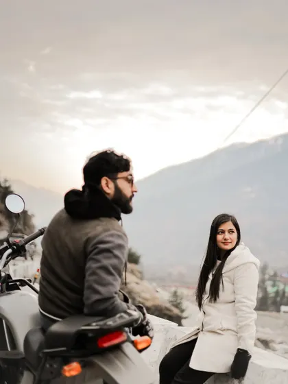 A candid moment between a couple on a bike, enjoying the mountain view in Manali.