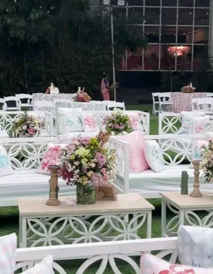 The white lounge furniture is accented with custom-printed pink and blue cushions.