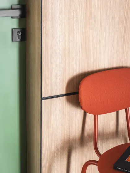 Meticulous attention to detail is a hallmark of our work. Here, the crisp black metal inlay provides a clean, graphic line between the green door and the warm oak wall panel.