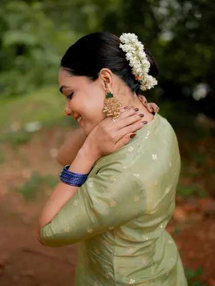 A candid portrait of actress Anupama Gowda, capturing a moment of laughter. The natural setting and her joyful expression make for a beautiful and authentic shot.