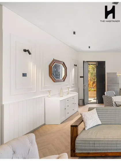 The living room of the Denkanikotta prefab home features elegant wall molding and a mix of modern and classic furniture. The design creates a sophisticated yet comfortable atmosphere.