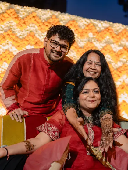 The bride with her mother and brother, all smiles during the vibrant Mehendi ceremony.