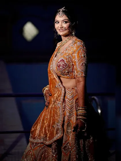 A full-length shot of the bride, showcasing the unique color and design of her lehenga.