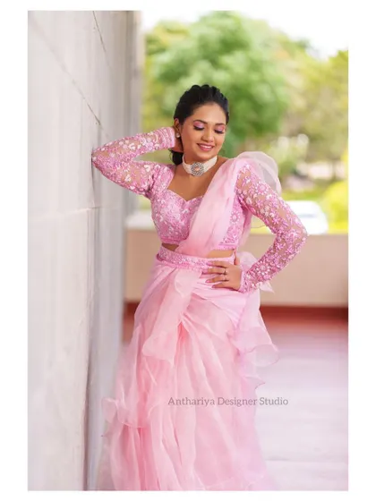 A side view of the pink ruffled outfit, highlighting the embroidered full-sleeve blouse.