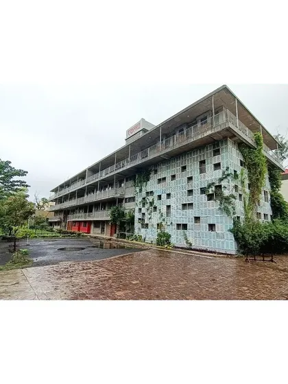 A wide view of the Eklavya campus building, showing how the green facade has matured over time, blending the structure into its surrounding landscape.