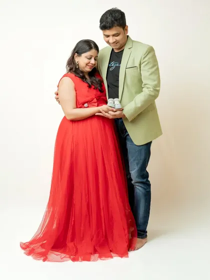 The couple looking down at a tiny pair of baby shoes held in their hands. This pose symbolizes the little life they are eagerly waiting to meet.