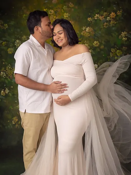 A warm embrace against a painterly floral backdrop. The partner's kiss on her forehead adds a layer of love and security to the portrait.
