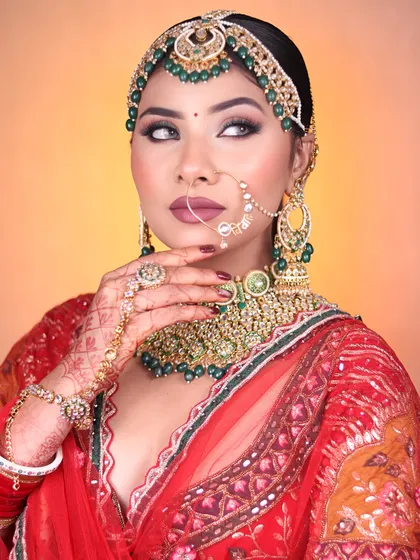 A classic bridal look taught in our pro course, featuring bold green jewelry against a red lehenga and dramatic eye makeup.