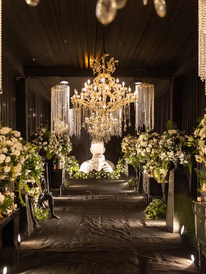 I believe in creating unique atmospheres, like this modern and dramatic Sangeet decor. The high-contrast theme with black draping, crystal chandeliers, and contemporary art installations offers a sophisticated and luxurious alternative to traditional setups, perfect for a chic evening celebration.