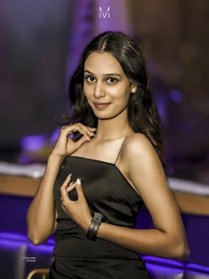 A sweet and engaging portrait, the model's gentle smile and pose create a warm and inviting atmosphere amidst the cool club lighting.