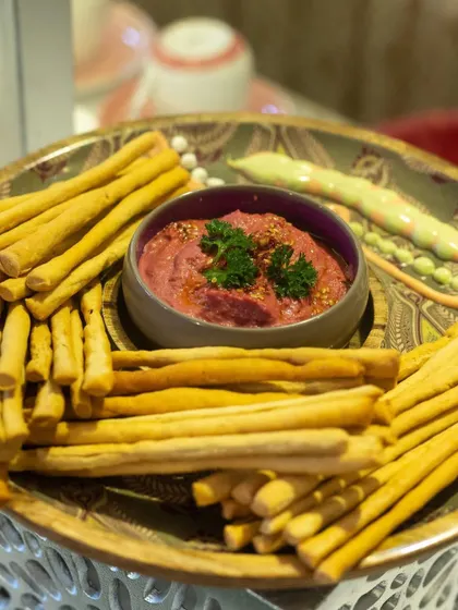 Crispy breadsticks served with a vibrant beetroot hummus. This simple yet delicious combination is a perfect snack or starter for any event.