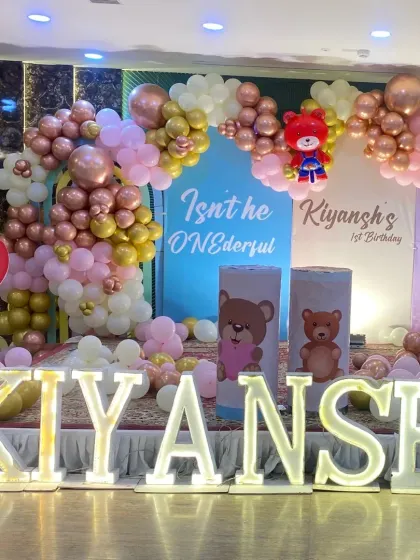An angled view of the teddy bear themed stage, highlighting the hot air balloon prop and the extensive balloon garland.