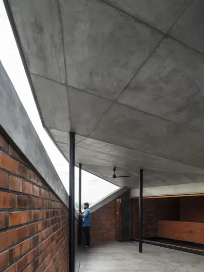 The combination of exposed brick walls and a board-formed concrete ceiling in the Brick House creates a rich textural palette, celebrating the honesty of local materials.