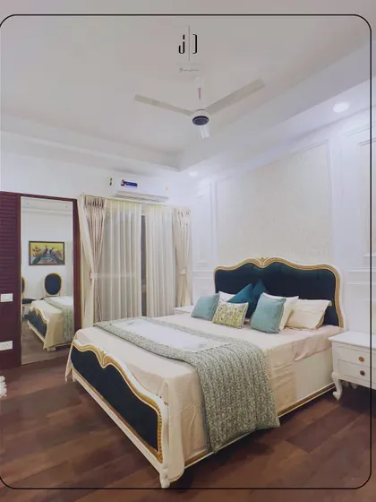 A classic bedroom design with a four-poster bed and elegant white and gold accents. The wooden flooring and simple decor create a timeless and sophisticated look.