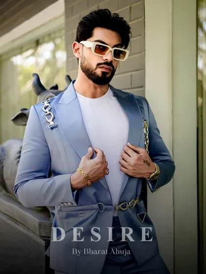 A closer view of the light blue blazer, highlighting the unique chain-link hardware and the smooth, satin-like texture of the fabric.