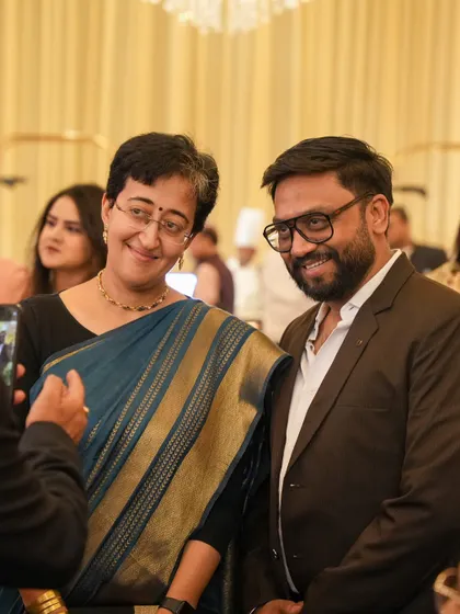 Esteemed guests, including Atishi Marlena, enjoying a moment at one of our catered events. Our service is designed to be discreet, professional, and polished, allowing guests to connect and enjoy.