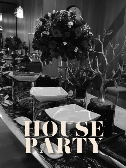 A chic black and white themed house party. The dramatic floral arrangements and high-contrast decor create a modern and stylish atmosphere.