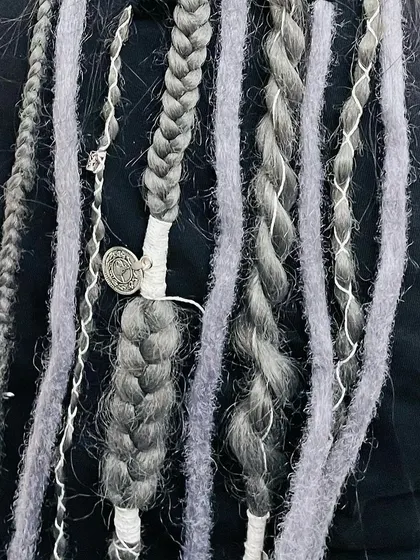 A closer look at the craftsmanship. I mix different textures, including soft wrapped locs and tight braids, and finish the look with custom thread wraps and a small metal charm. Every detail is tailored to create a unique and personal style.