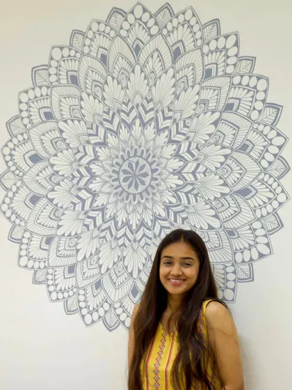 A side view of a completed grey and white mandala mural, showing how the design's symmetry works from every angle in the room.