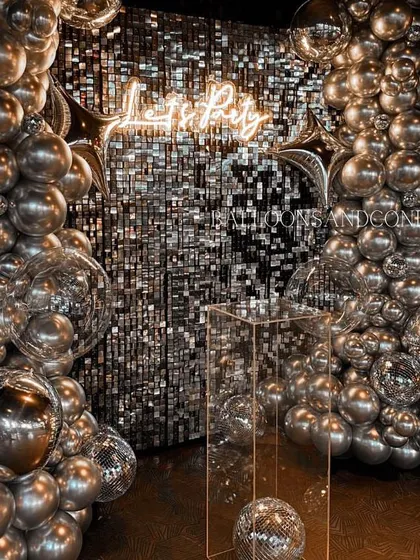 Another perspective of the silver disco setup, showing how the balloon garlands frame the sequin wall and create an immersive party environment.