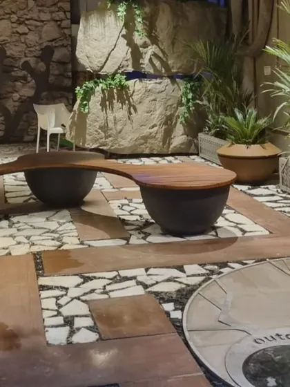 An overview of a completed landscape project featuring custom flooring, a water feature, and a unique curved bench, demonstrating our ability to create holistic outdoor environments.