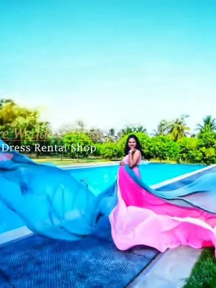 A vibrant, multi-colored flying gown in shades of blue and pink, captured by a poolside. The bright colors are perfect for a fun, tropical-themed shoot.