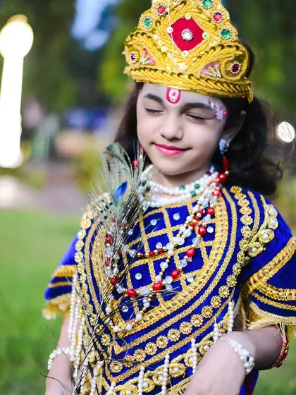 A serene, eyes-closed pose that captures a moment of divine contemplation for this little Krishna.