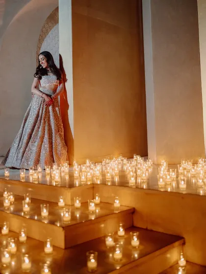 The bride, glowing in a candlelit setting during her Sangeet night in Marrakech.