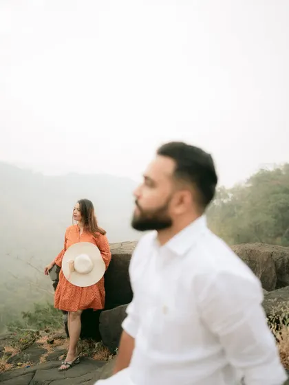 A creative shot using foreground blur to create depth and focus on the bride, adding an artistic touch to the pre-wedding session.