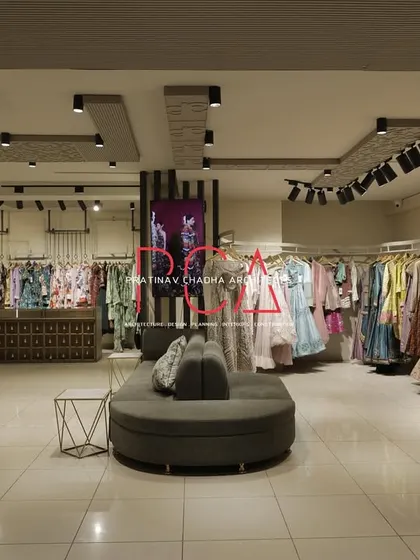 This wide shot of the Jubinav Chadha Fashion Design Studio in New Delhi captures the overall retail environment I created. The design, inspired by Indian temple carvings, features a central seating area, custom display racks, and strategic track lighting to create an immersive and high-end shopping experience.