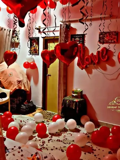 A room filled with love for a birthday surprise. This decoration includes red and white balloons, heart-shaped foils, and a "Love" balloon banner.