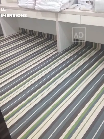 Striped carpet tiles installed in an office space, fitting neatly under the desks. This design is modern and helps to visually elongate the room.