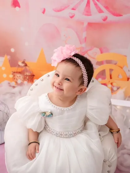 A close-up of the birthday girl, her happy smile lighting up the entire whimsical, star-filled studio setup.