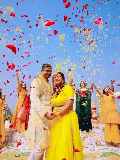A wide-angle shot of the flower shower, capturing the blue sky and the explosion of colorful petals. It's a moment of pure celebration.