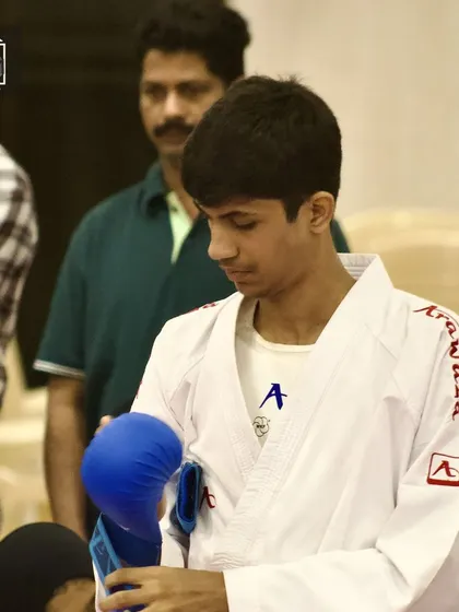A moment of focus. A student prepares his gloves before stepping onto the mat. The pre-fight ritual is a key part of getting into the right mindset for competition.