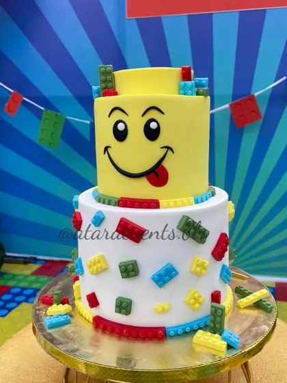 A fun and playful LEGO head cake, complete with edible bricks, serves as the centerpiece of the dessert display.