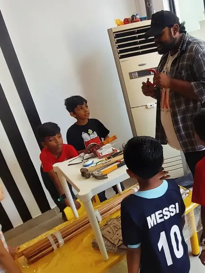 An instructor explains the different types of tools and their uses to an attentive group of kids. This is where every workshop begins.