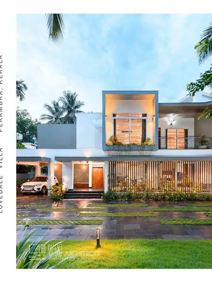 An evening view of Lovedale Villa, where architectural lighting highlights the projecting volumes and vertical wooden slats, creating a warm and modern aesthetic.