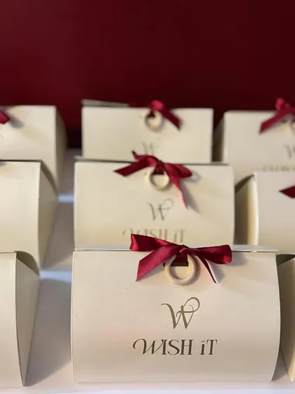 A closer view of the "Wishlet Kits" with their rich maroon ribbons. The simple, clean design makes them a versatile choice for any gifting need.