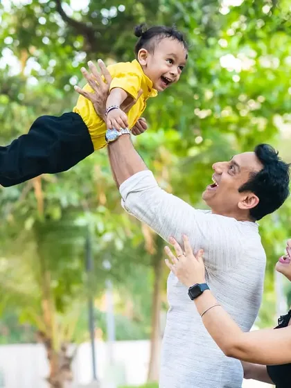 "I believe I can fly." This action shot of a father playfully lifting his son is full of energy and laughter, a perfect memory from their family photoshoot.