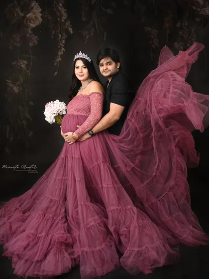 A majestic couple's portrait with a flowing gown. The fabric toss adds a sense of drama and movement, making the mom-to-be look like a queen.