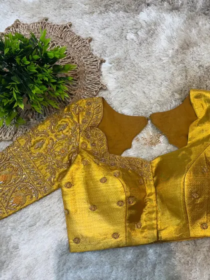 The front of the mustard yellow blouse, with a unique neckline and subtle embroidery that complements the heavily worked sleeves.