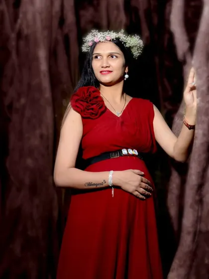 A beautiful solo maternity portrait. This simple red gown is accessorized with a floral hairpiece and a statement belt, showing how you can personalize your look.