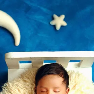 Dreaming among the stars. This overhead shot of a baby sleeping on a tiny bed with a moon and star creates a celestial, dreamy atmosphere.
