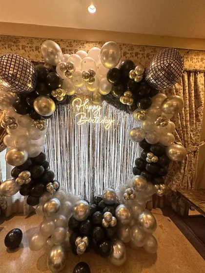 A close-up of the disco-themed balloon arch, featuring shiny disco ball foil balloons mixed with black, white, and silver latex balloons for a glamorous effect.